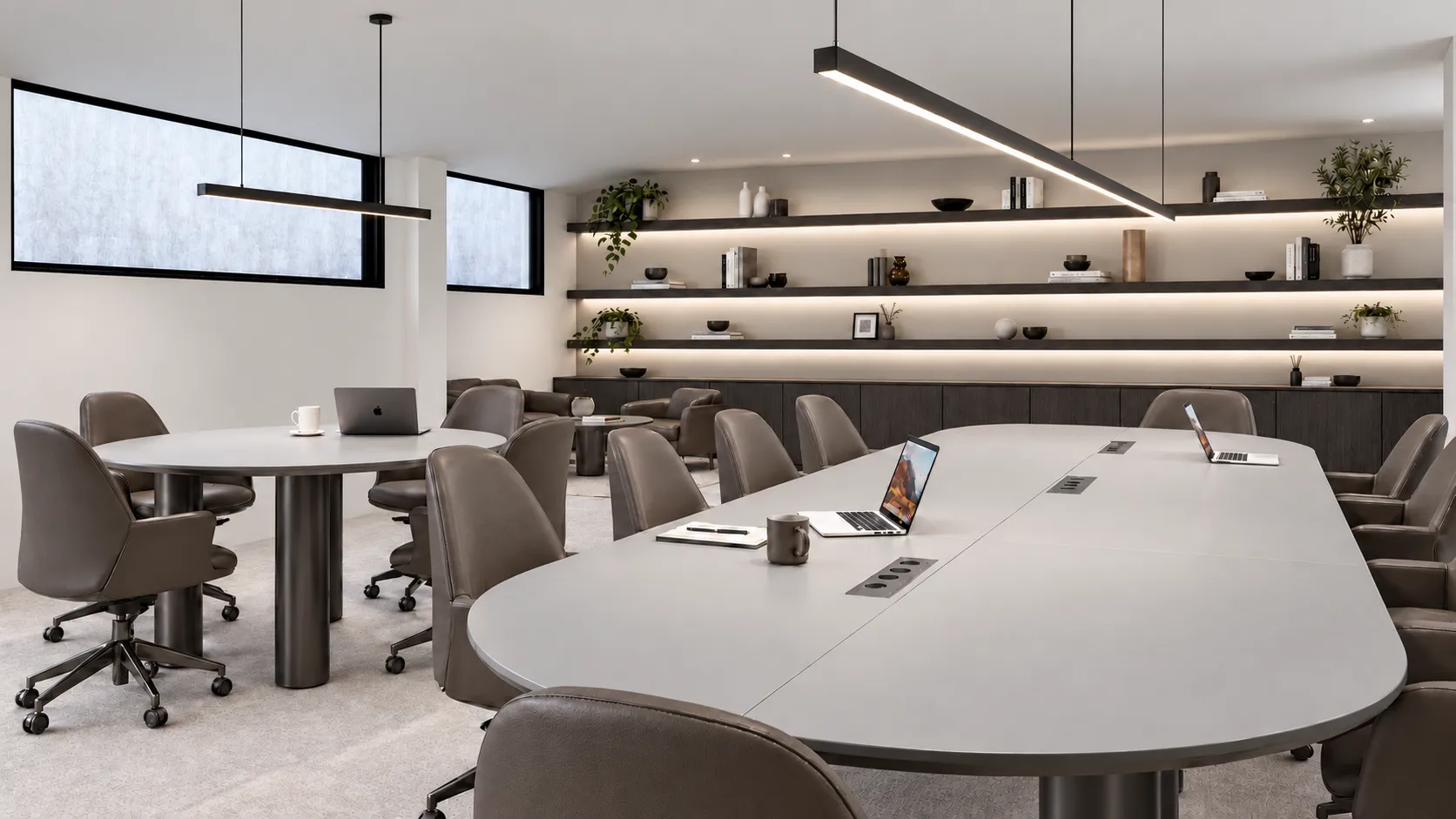 Executive business lounge con grande tavolo riunioni, postazioni di lavoro e libreria illuminata